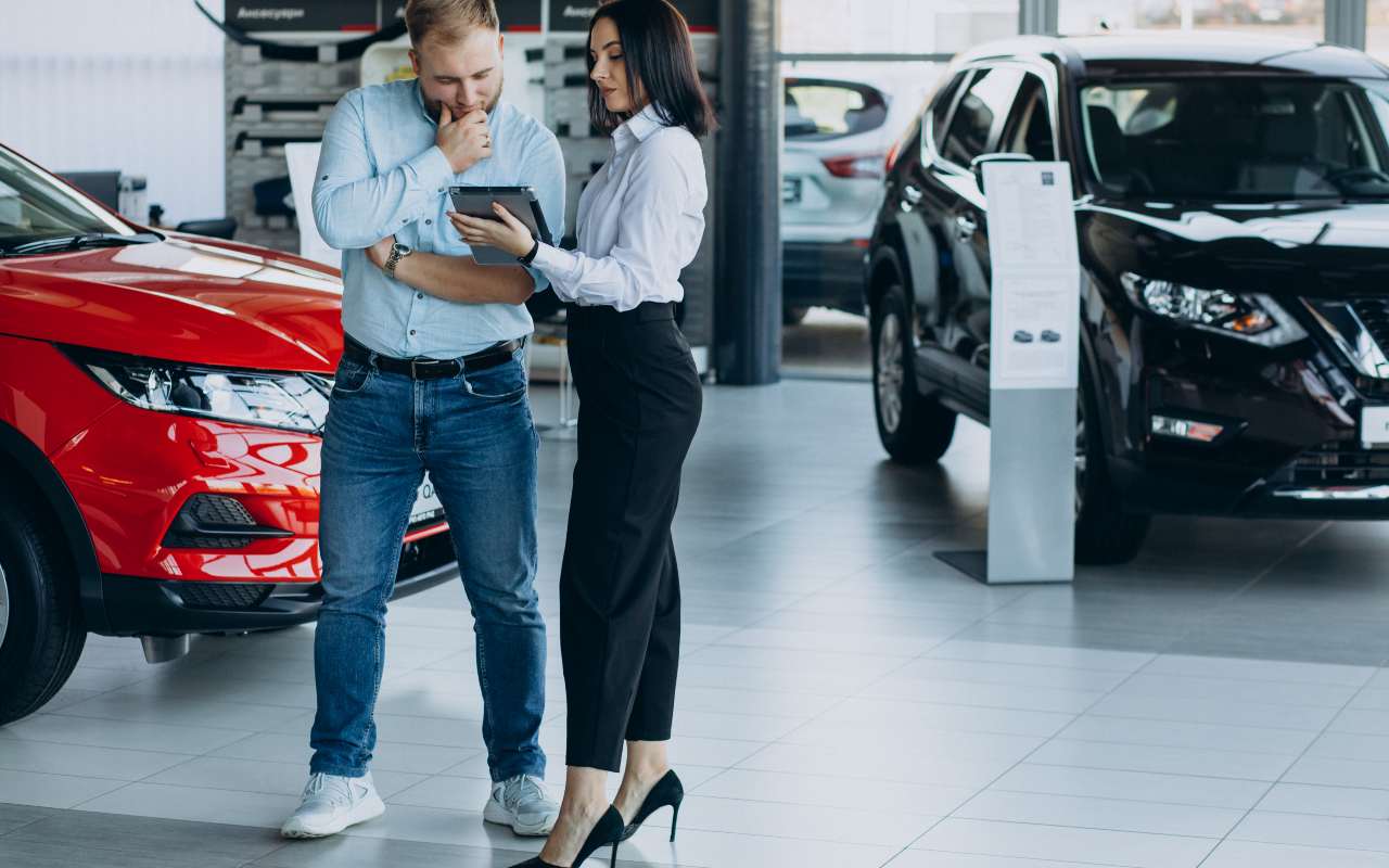 Due persone controllano le caratteristiche di una macchina in uno showroom di auto elettriche