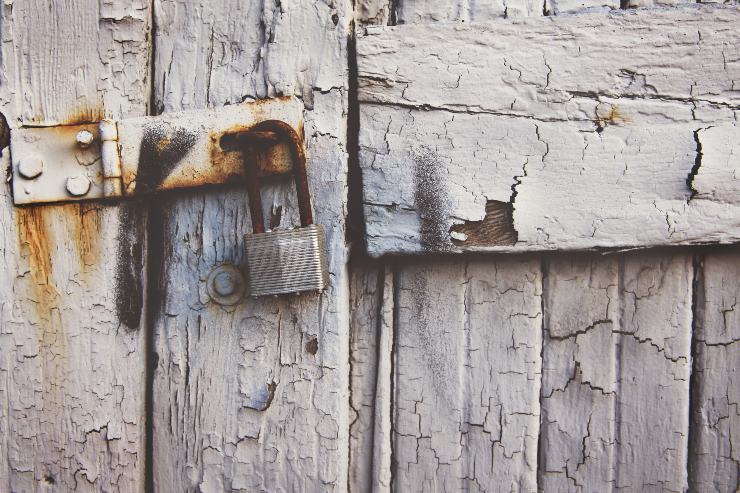 Una porta di legno con lucchetto e simbolo di ladri