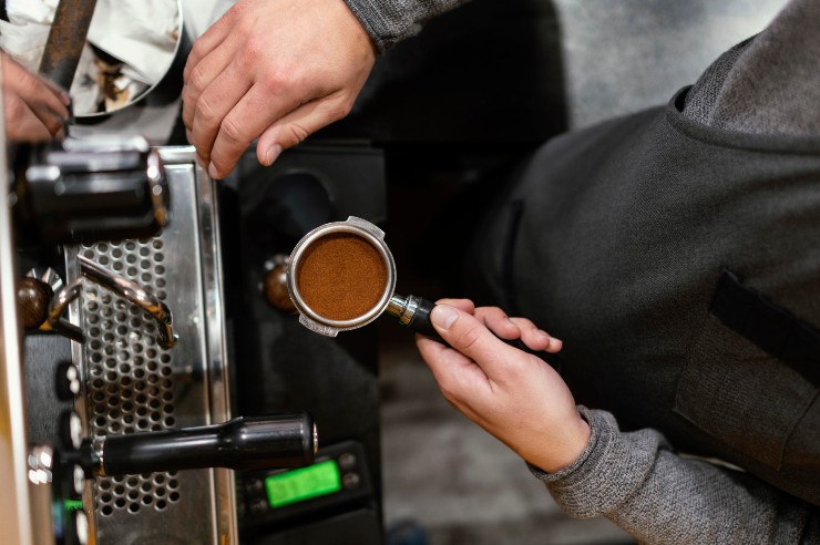 Un barista sistema la miscela di caffè nella macchina da bar